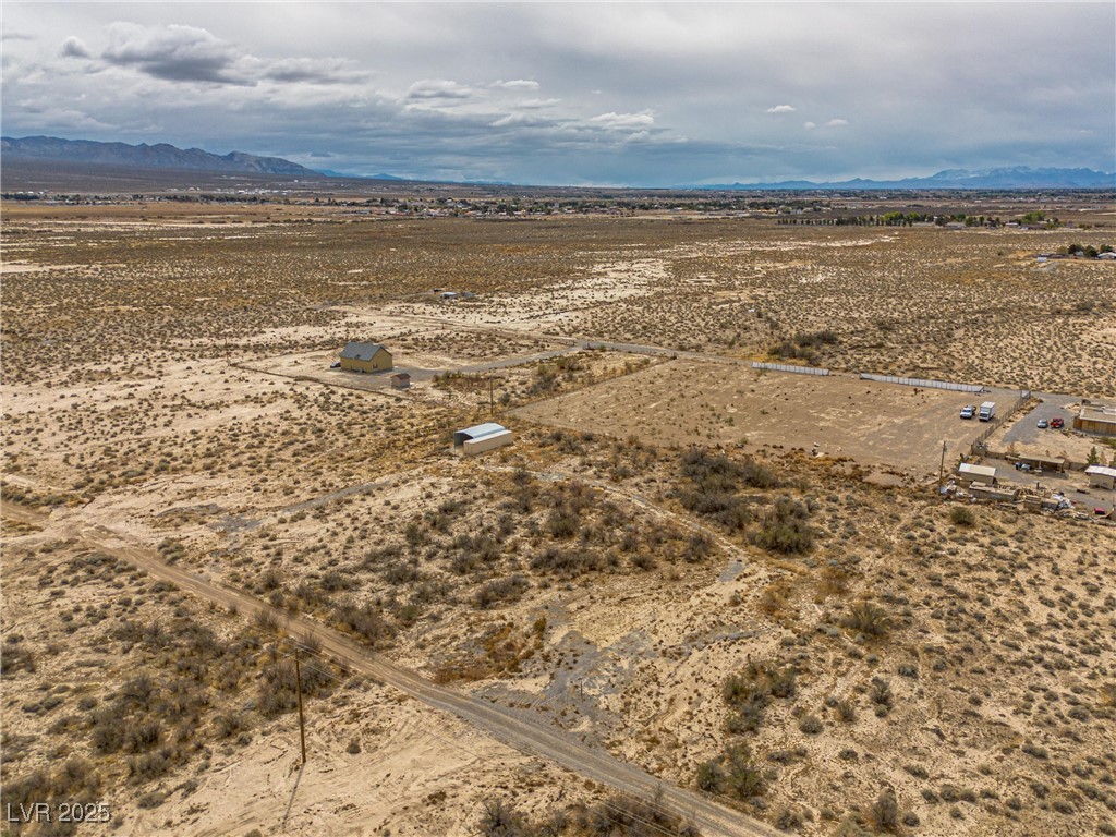 1411 West Harris Farm Road Pahrump, NV 89060 - Photo 6 of 25 Aerial view featuring a rural view, view of desert, and a mountain view