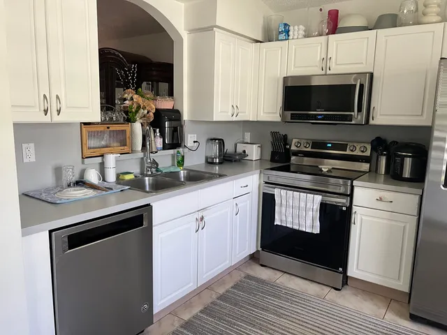 a kitchen with stainless steel appliances a refrigerator a stove a microwave and sink