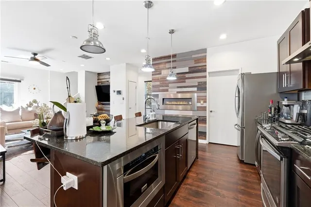 a kitchen with stainless steel appliances a sink a stove and a wooden floors
