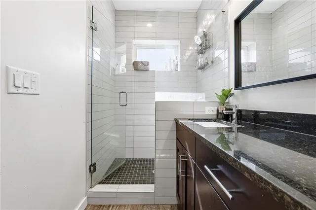 a bathroom with a sink a granite counter and a mirror