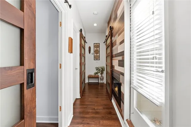a hallway with wooden floor and staircase