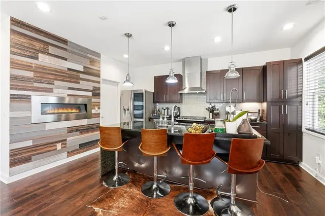 a kitchen with stainless steel appliances granite countertop a refrigerator and a stove top oven