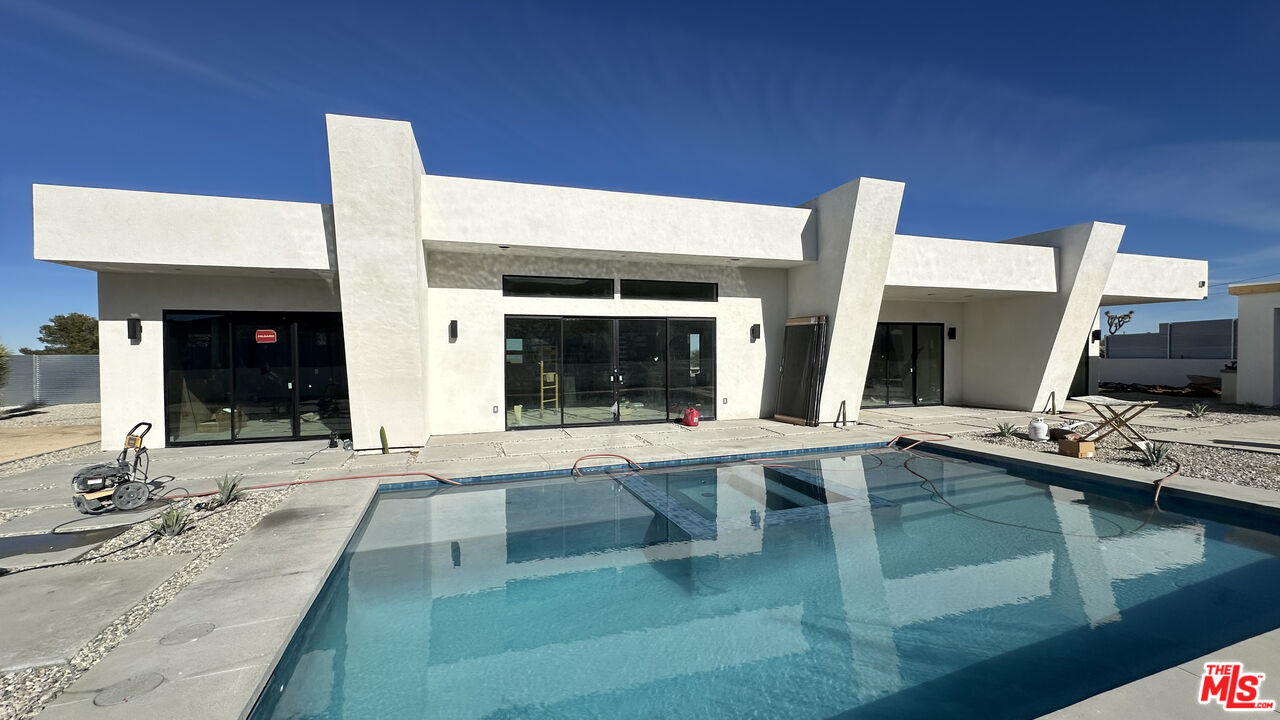 60277 Pueblo Trail Joshua Tree, CA 92252 - Photo 1 of 1 a large white building with a large window in front of it