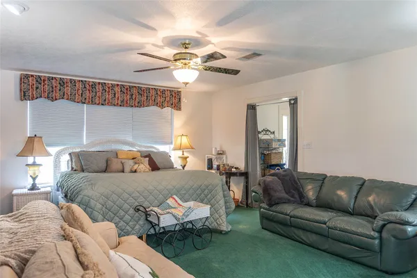 a bedroom with a bed couch and window