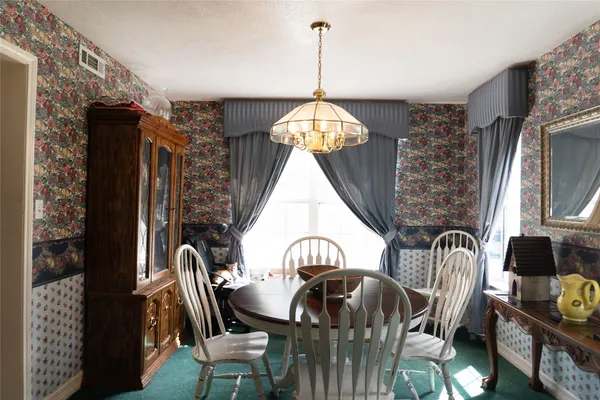 a view of a dining room with furniture and chandelier