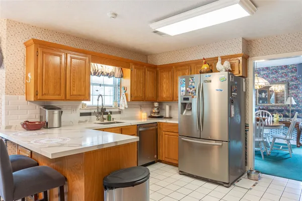 a kitchen with stainless steel appliances granite countertop a refrigerator a sink a stove and island