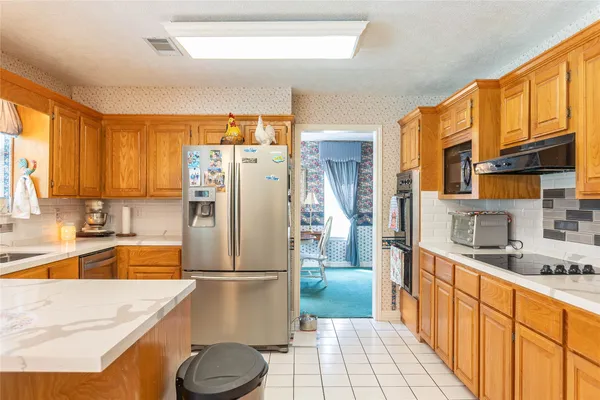 a kitchen with stainless steel appliances granite countertop a refrigerator a sink and a stove