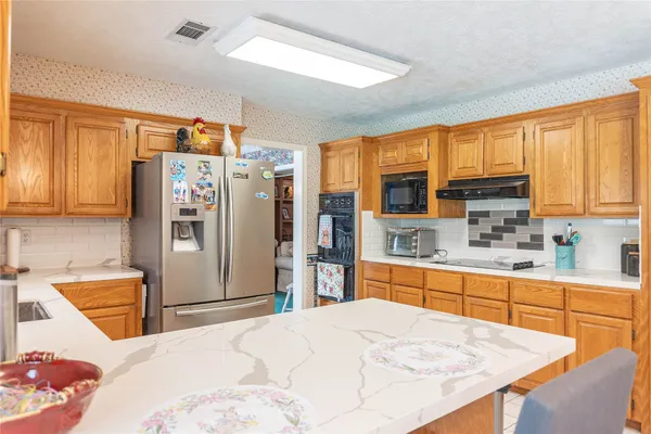a kitchen with stainless steel appliances granite countertop a refrigerator sink and cabinets
