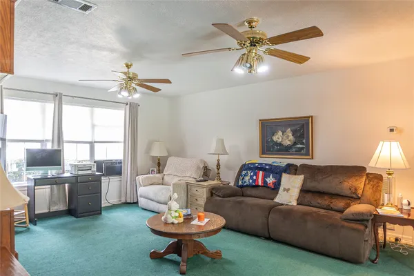 a living room with furniture a fireplace and a chandelier