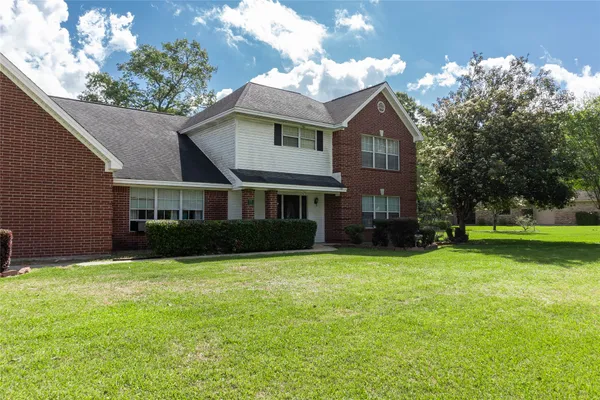 a view of a house with a yard and tree s