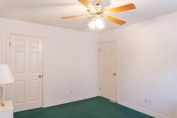 an empty room with closet and fan