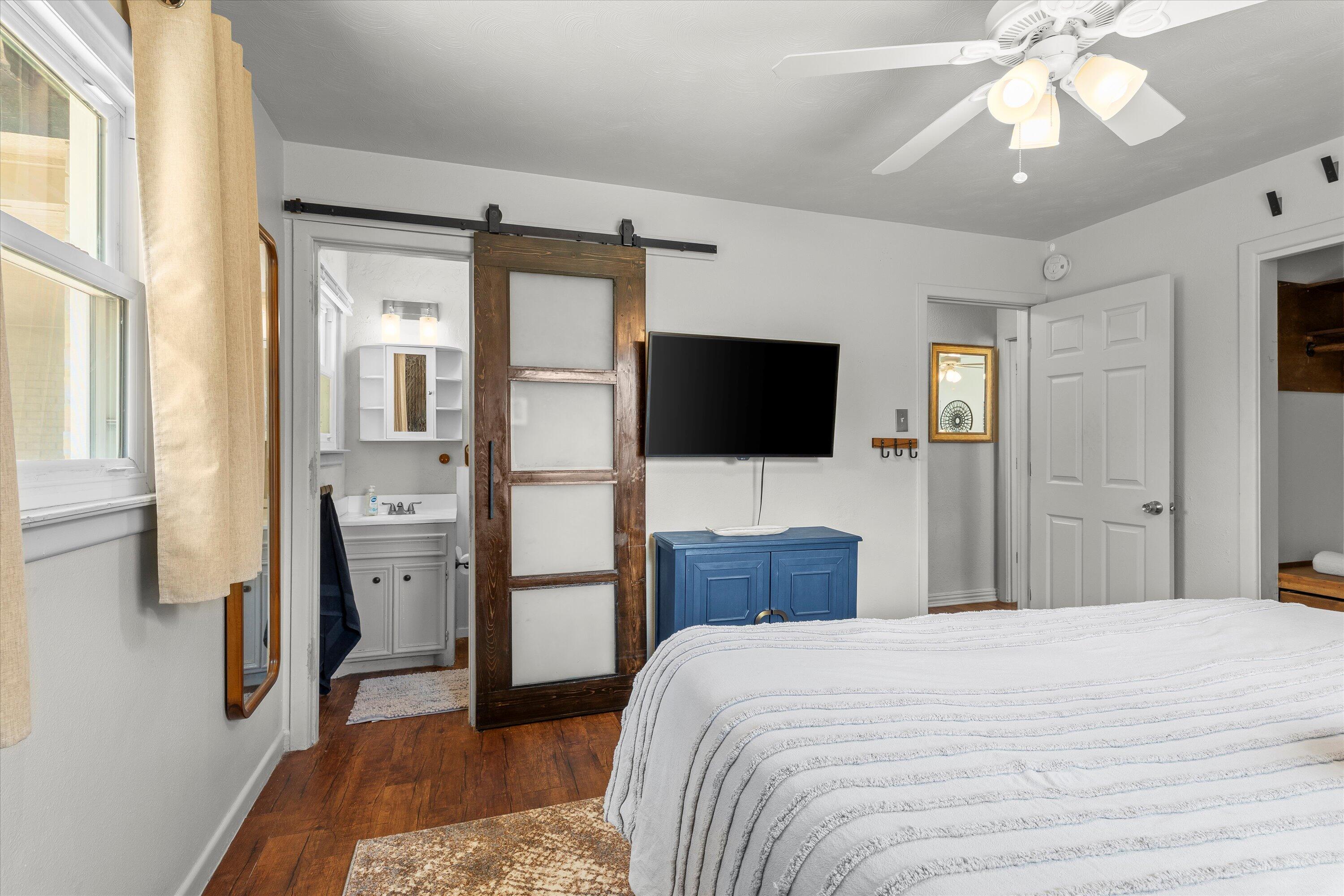 5305 13th Street Lubbock, TX 79416 - Photo 14 of 31 a bedroom with a bed and a flat tv screen on dresser