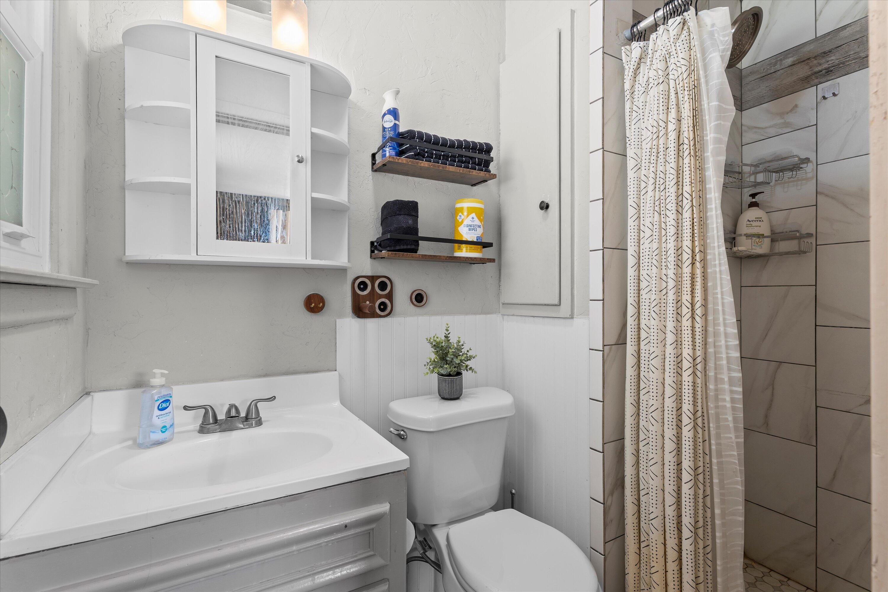 5305 13th Street Lubbock, TX 79416 - Photo 15 of 31 a bathroom with a sink a toilet and shower curtain