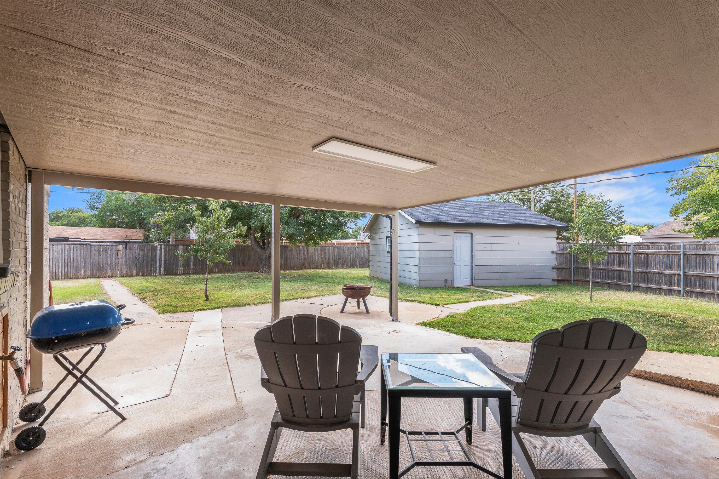 5305 13th Street Lubbock, TX 79416 - Photo 25 of 31 a view of a patio with table chairs and a yard