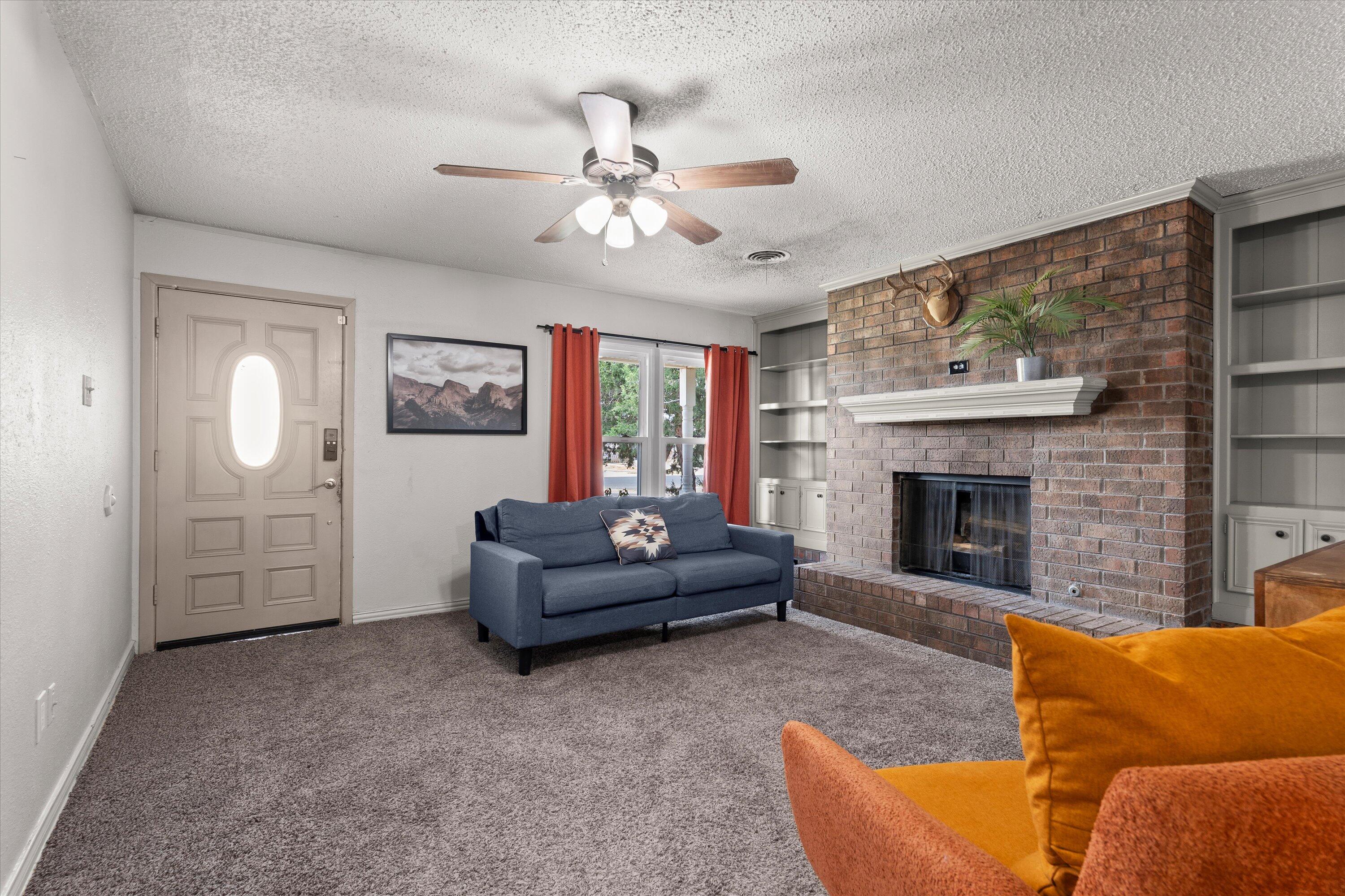 5305 13th Street Lubbock, TX 79416 - Photo 4 of 31 a living room with furniture and a fireplace