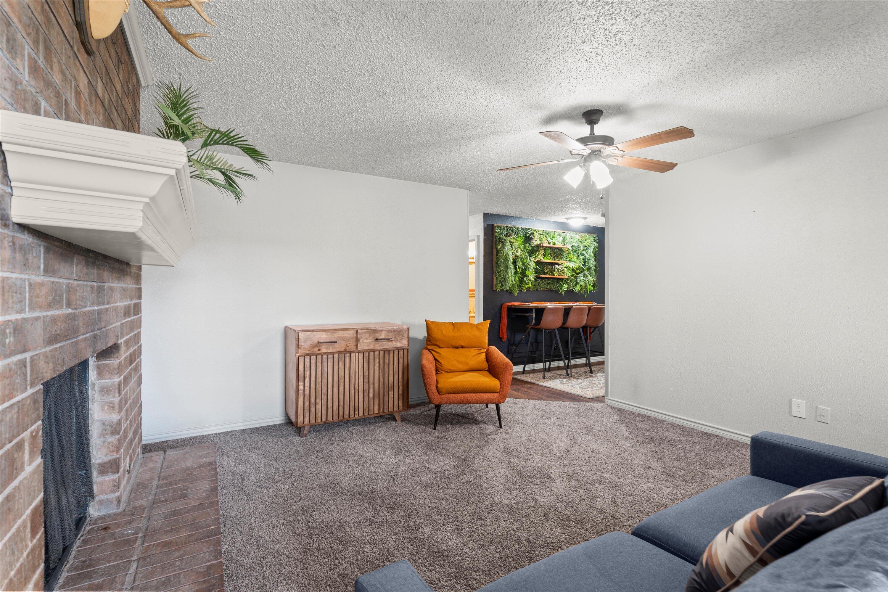5305 13th Street Lubbock, TX 79416 - Photo 6 of 31 a living room with furniture and a fireplace