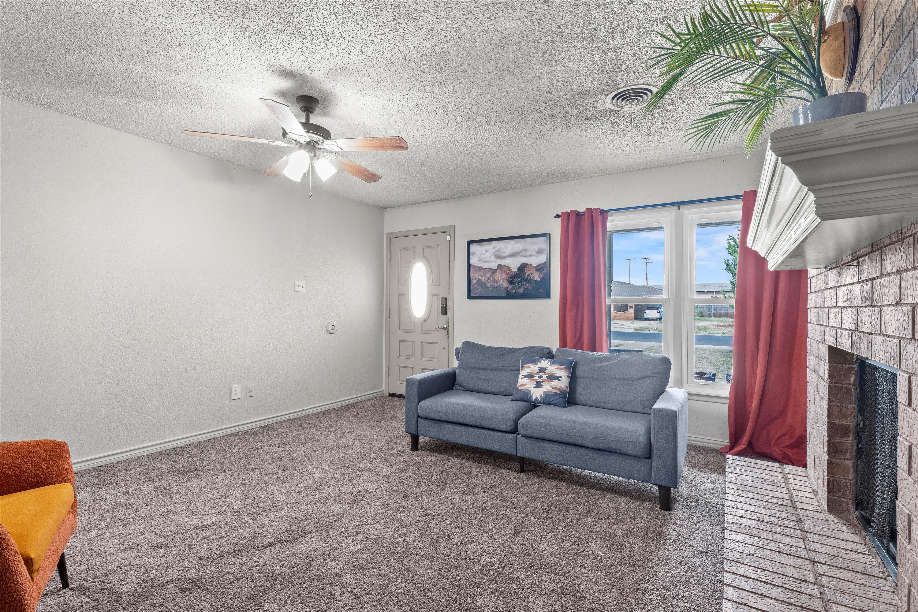 5305 13th Street Lubbock, TX 79416 - Photo 7 of 31 a living room with furniture and a fireplace