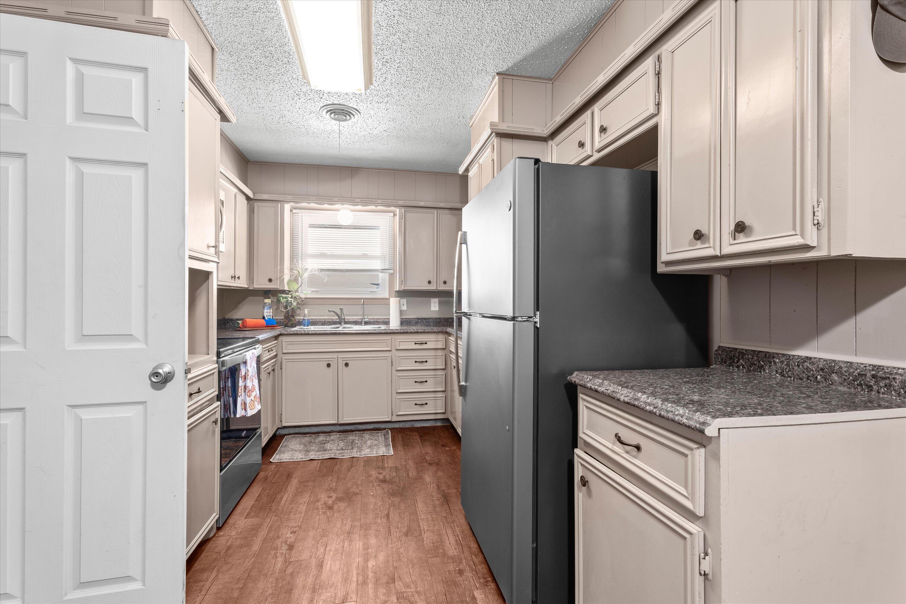 5305 13th Street Lubbock, TX 79416 - Photo 10 of 31 a kitchen with a refrigerator sink and cabinets