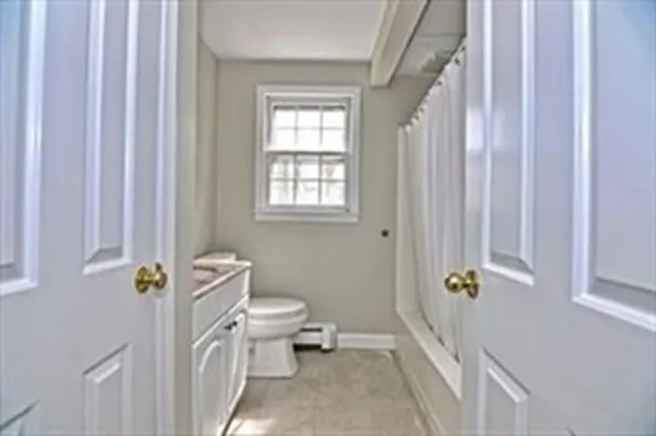 a bathroom with a window a toilet and a shower