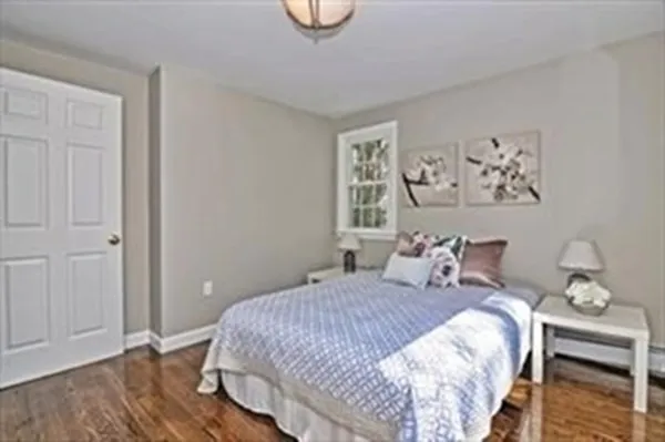 a bedroom with a bed and painting on the wall