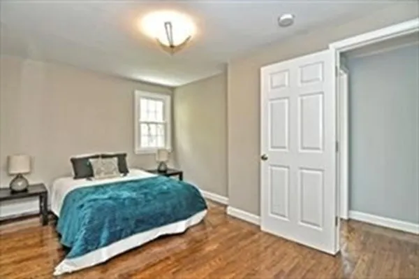 a bedroom with a large bed and a chandelier