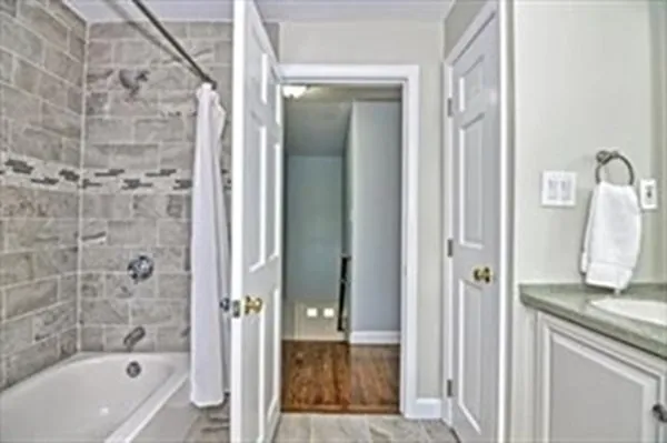 a bathroom with a granite countertop sink a mirror and a bathtub