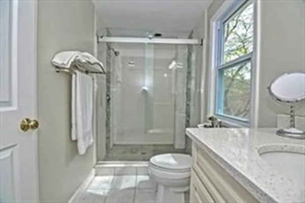a bathroom with a granite countertop sink toilet and shower