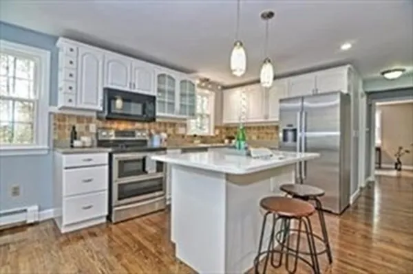 a kitchen with kitchen island granite countertop a sink cabinets and stainless steel appliances