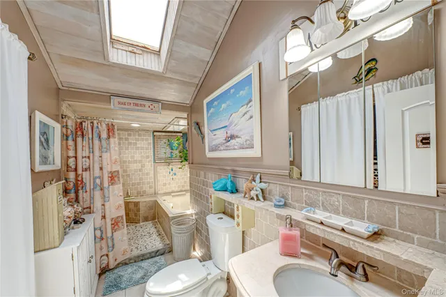 a bathroom with a granite countertop sink mirror vanity and toilet