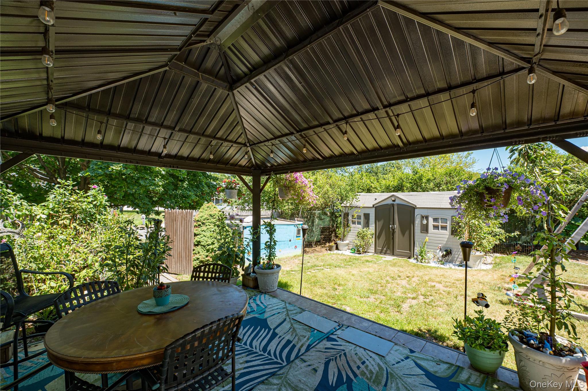 8 Woodbrook Drive, Unit 8 Ridge, NY 11961 - Photo 19 of 30 a view of a patio with table and chairs potted plants with floor to ceiling window and garden view