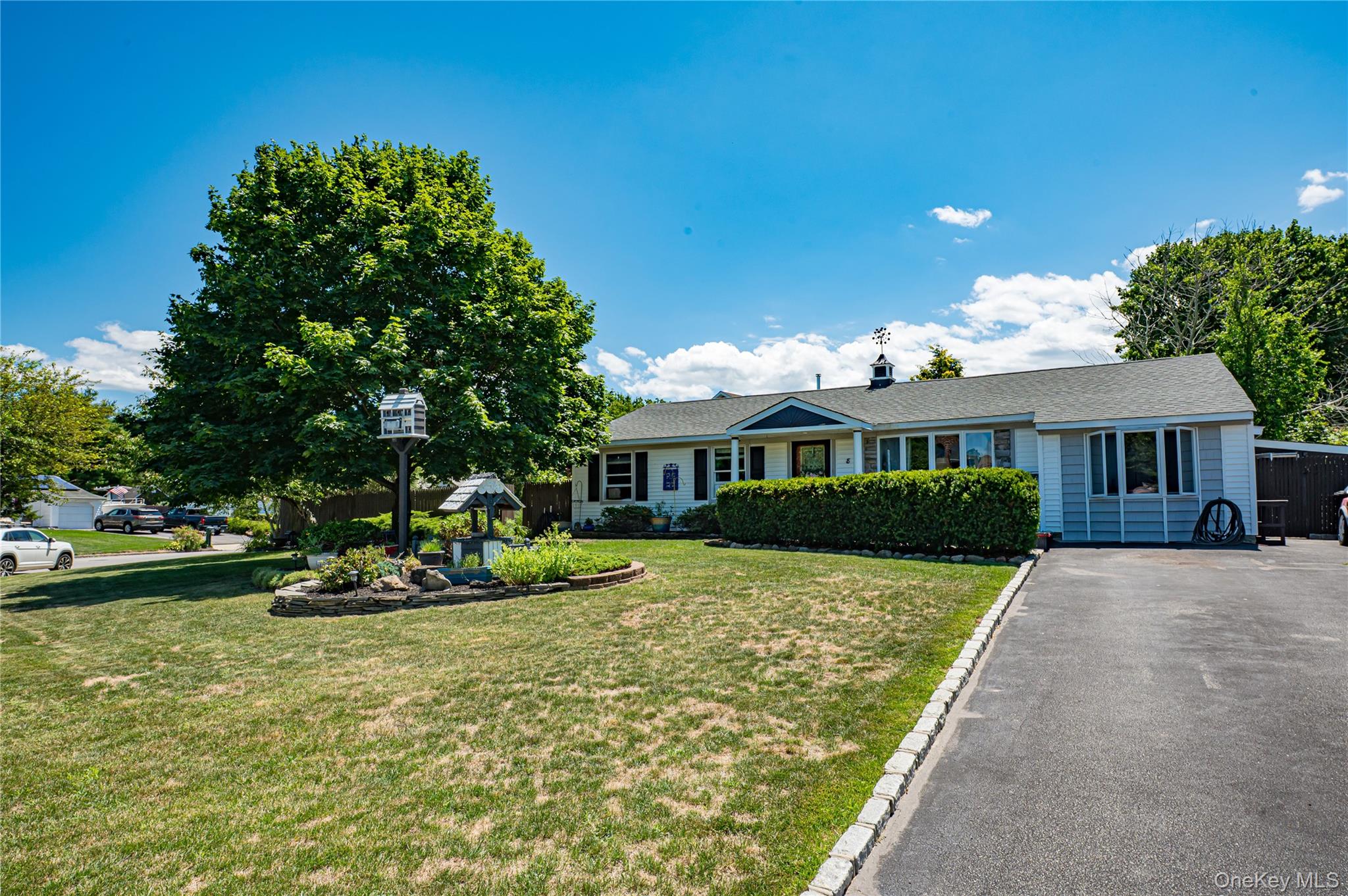 8 Woodbrook Drive, Unit 8 Ridge, NY 11961 - Photo 2 of 30 a front view of a house with a garden and porch
