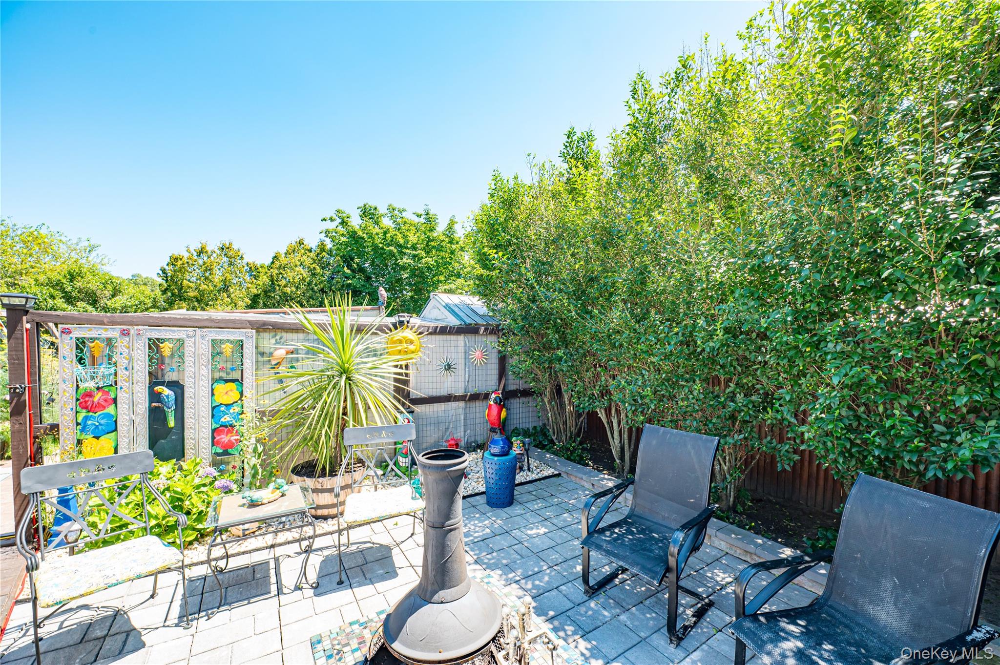 8 Woodbrook Drive, Unit 8 Ridge, NY 11961 - Photo 26 of 30 a view of a chairs and table in backyard