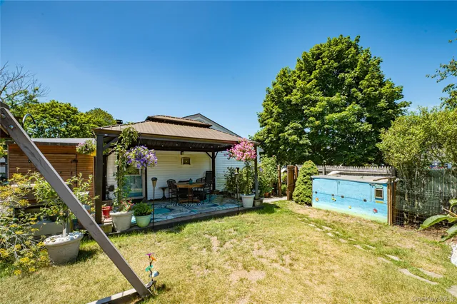 a backyard of a house with table and chairs with plants