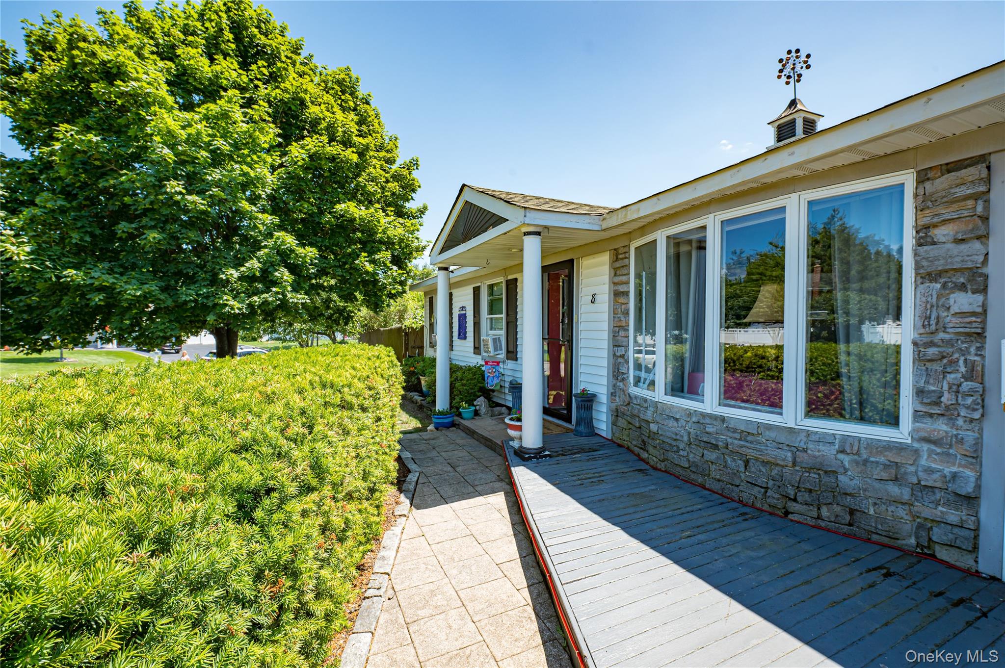 8 Woodbrook Drive, Unit 8 Ridge, NY 11961 - Photo 4 of 30 a front view of a house with a garden