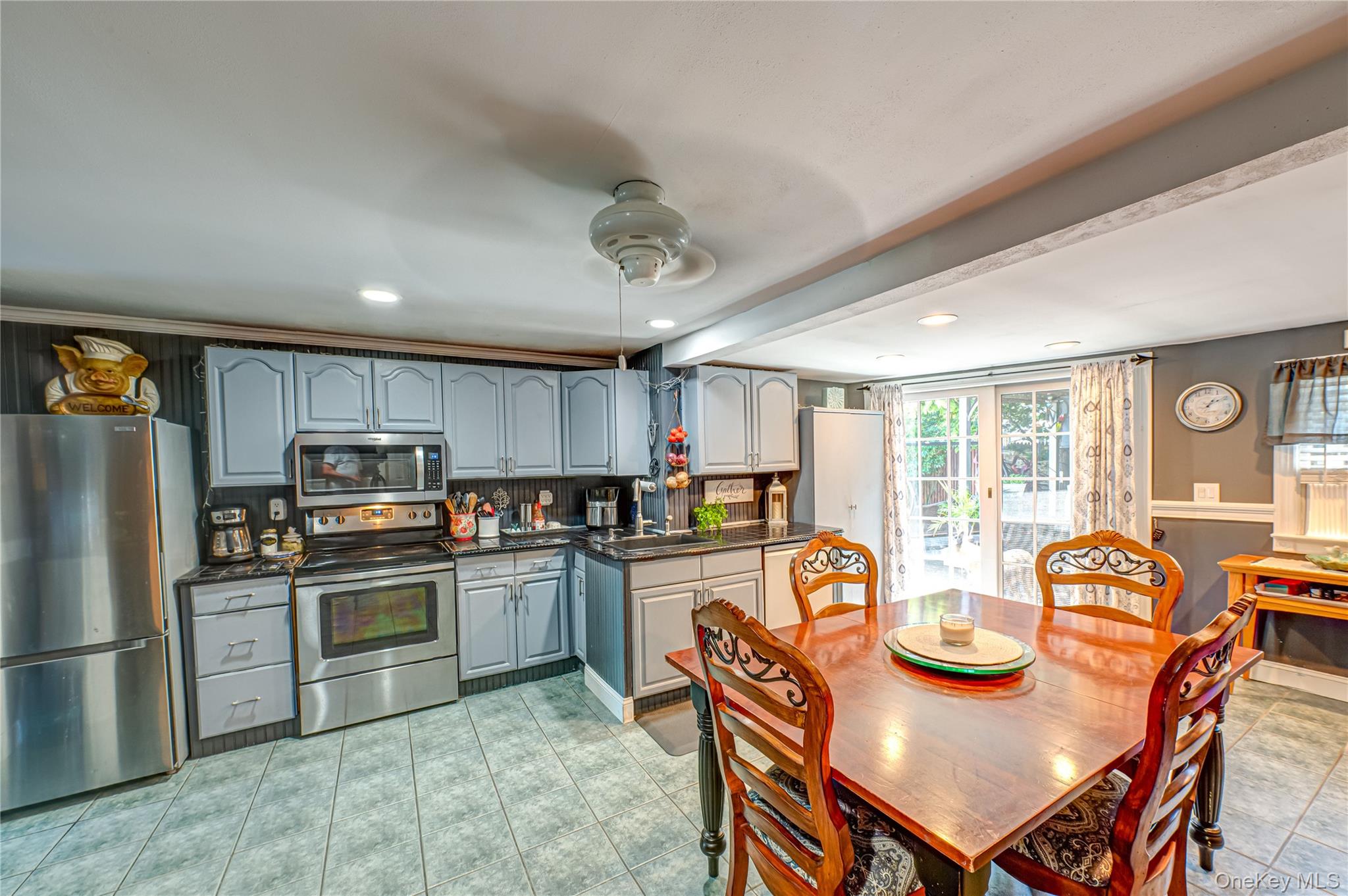 8 Woodbrook Drive, Unit 8 Ridge, NY 11961 - Photo 7 of 30 a kitchen with stainless steel appliances granite countertop a stove a refrigerator a sink dishwasher a dining table and chairs with wooden floor