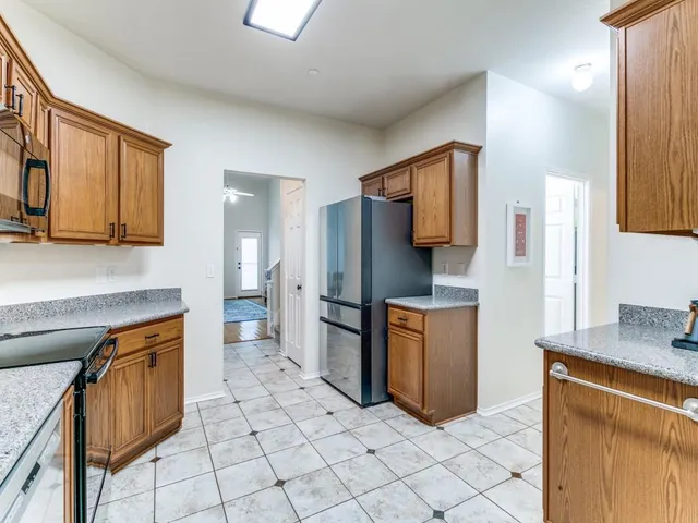 a kitchen with stainless steel appliances granite countertop a refrigerator and a stove top oven