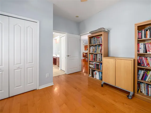 a view of an empty room with bookshelf and a window
