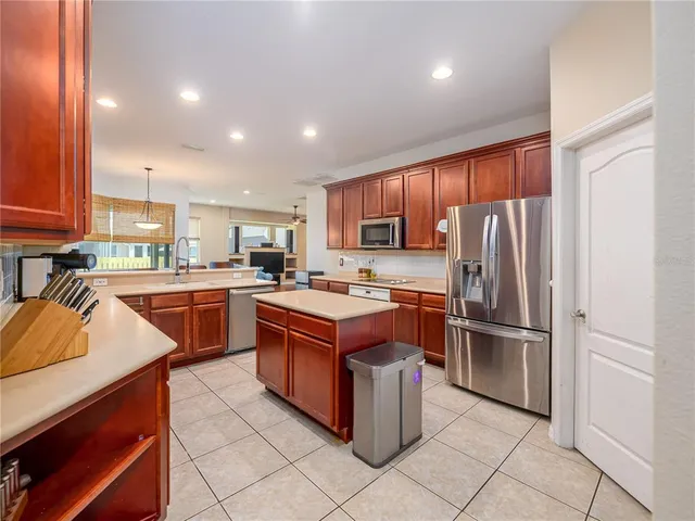 a large kitchen with stainless steel appliances granite countertop a stove refrigerator and a sink
