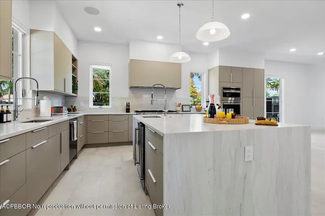 a kitchen with stainless steel appliances a sink a stove a refrigerator cabinets and a window