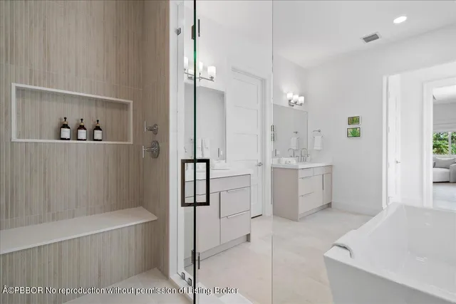 a bathroom with a tub sink shower and mirror