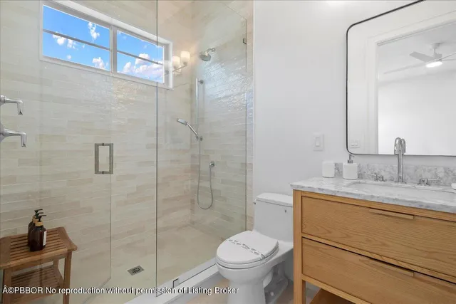 a bathroom with a granite countertop sink a toilet and shower