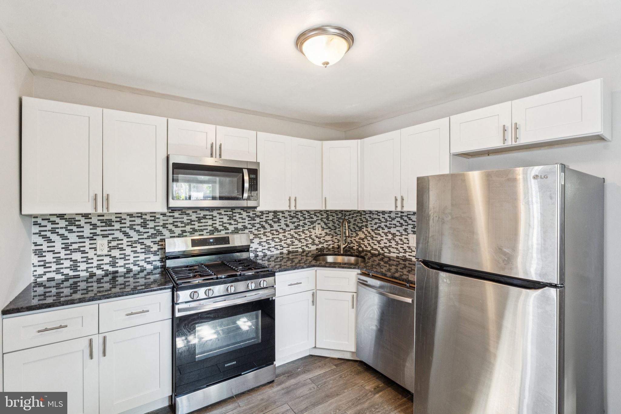 17 South 45th Street Philadelphia, PA 19104 - Photo 8 of 26 a kitchen with white cabinets and stainless steel appliances