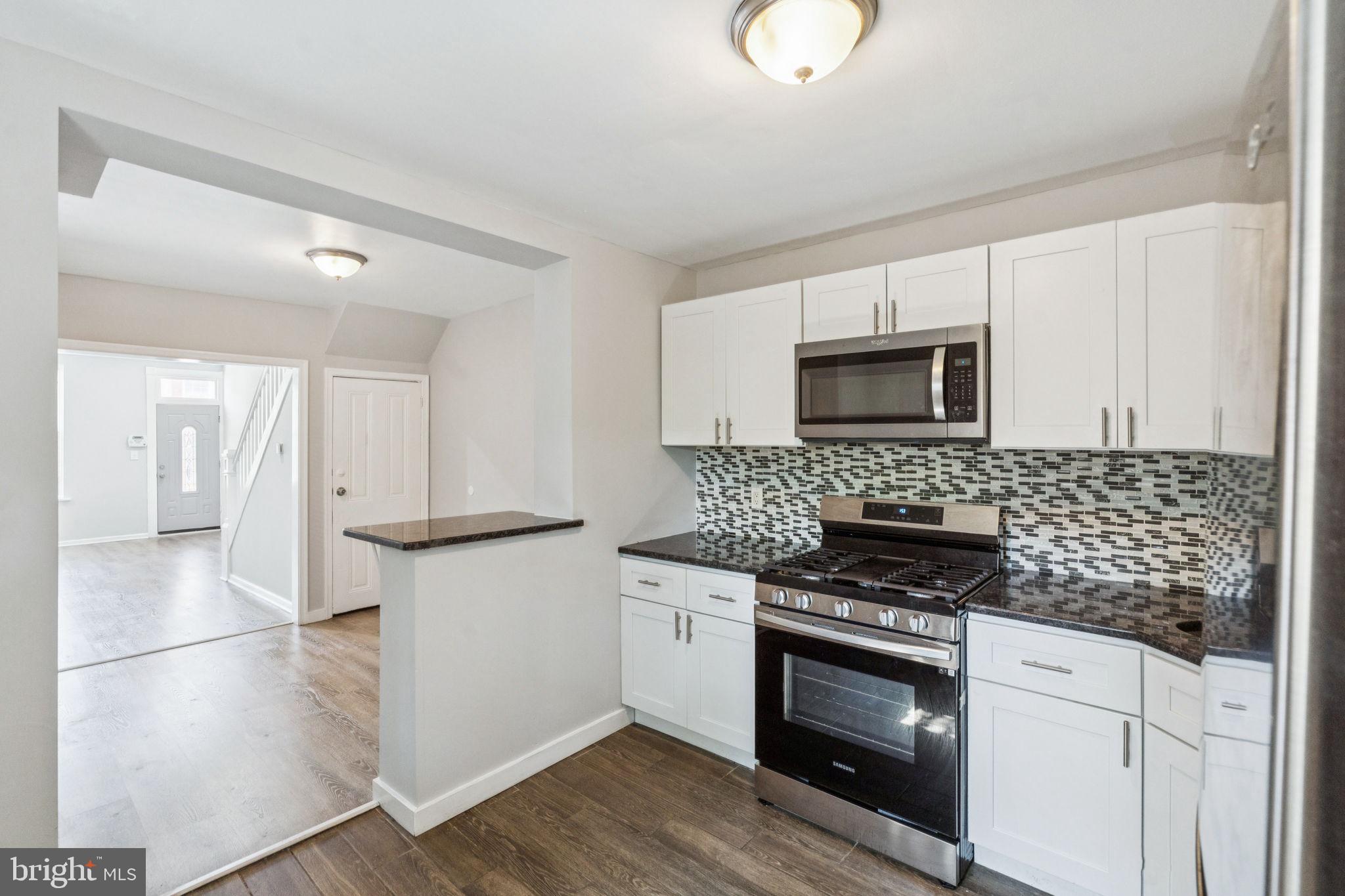 17 South 45th Street Philadelphia, PA 19104 - Photo 10 of 26 a kitchen with white cabinets and stainless steel appliances