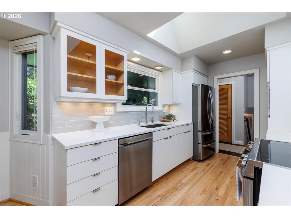 175 Northwest 95th Avenue Portland, OR 97229 - Photo 13 of 46 a kitchen with a sink cabinets stainless steel appliances and a window