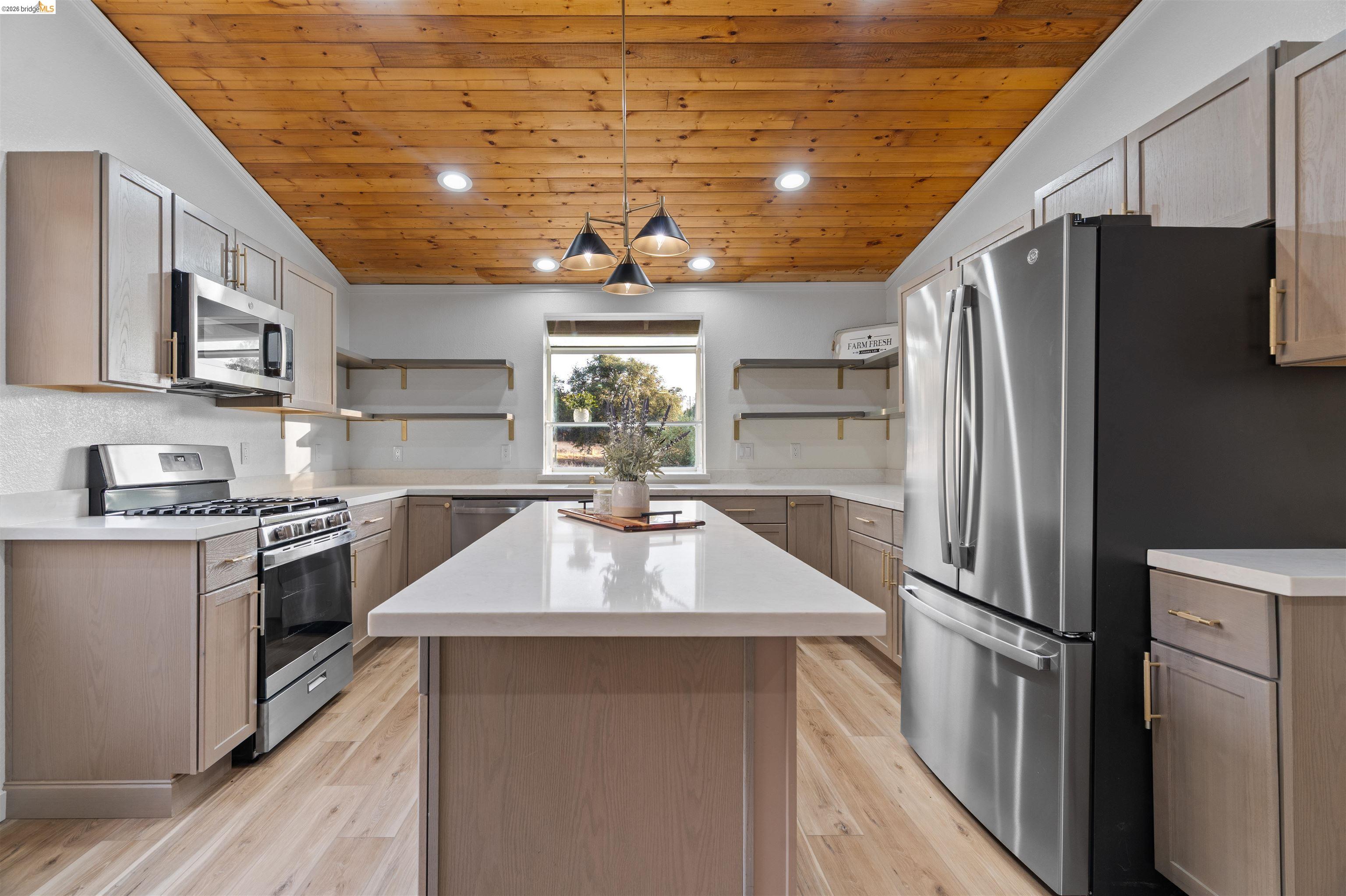 19676 Rawhide Road Sonora, CA 95370 - Photo 12 of 67 Kitchen featuring a wood plank ceiling, light wood-finish flooring, white countertops, built-in stainless steel appliances, and a central island