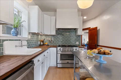 a kitchen with stainless steel appliances granite countertop a refrigerator a stove and a sink