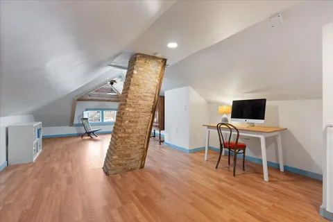 a view of a hallway with wooden floor and door