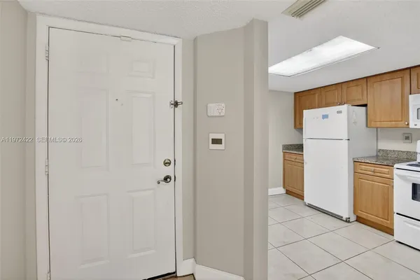 a white refrigerator freezer and a stove sitting inside of a kitchen