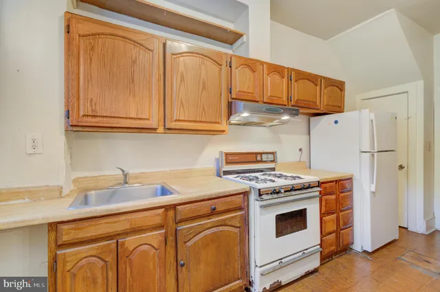 a kitchen with stainless steel appliances granite countertop a stove a refrigerator and a sink with cabinets