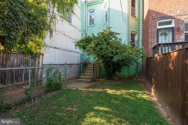 a view of a brick house with a small yard